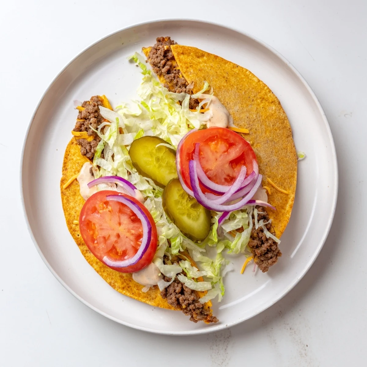 Smashburger Quesadillas stuffed with seasoned ground beef and cheese topped with fresh lettuce tomato pickles