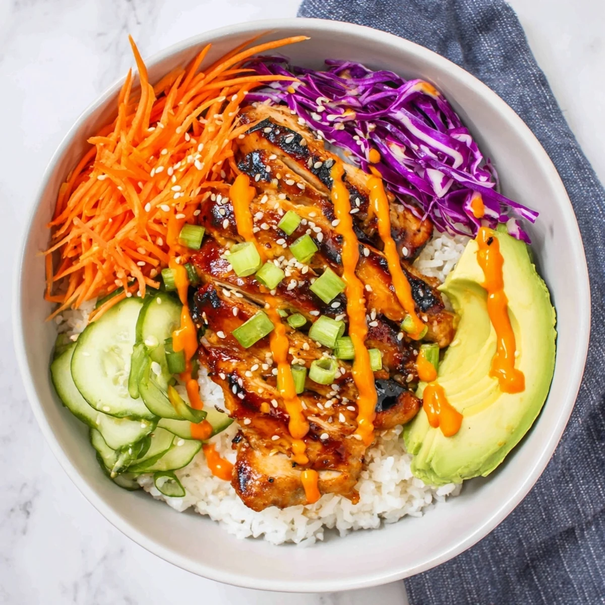 Golden grilled Korean BBQ chicken slices resting over fluffy white rice with colorful shredded vegetables and creamy gochujang mayo drizzle