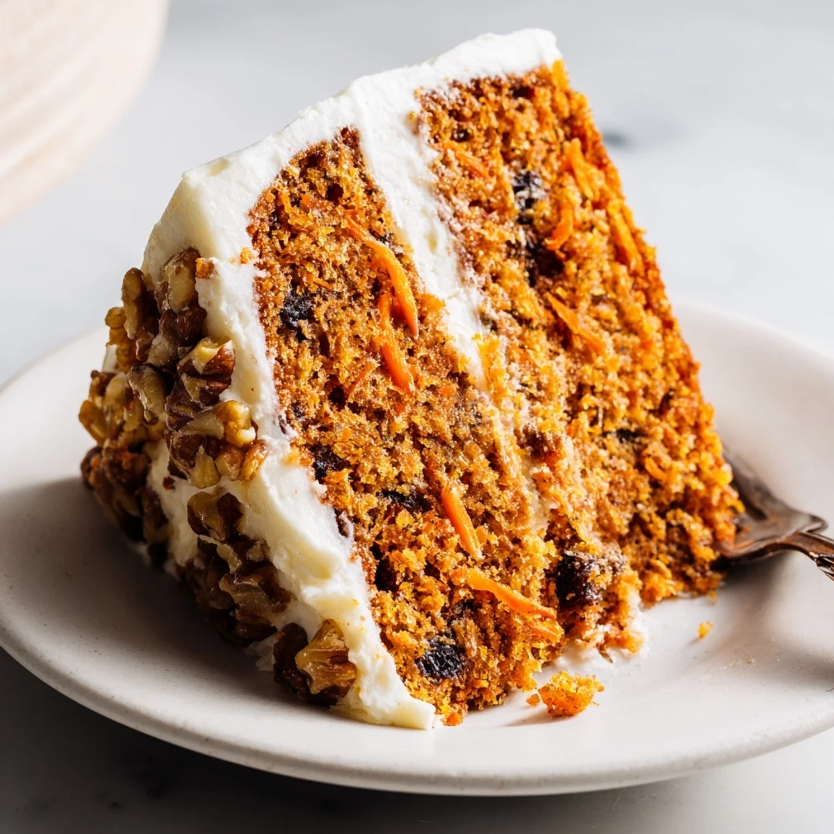 Delicious one-bowl carrot cake made with Greek yogurt featuring chopped walnuts and tender textured crumb