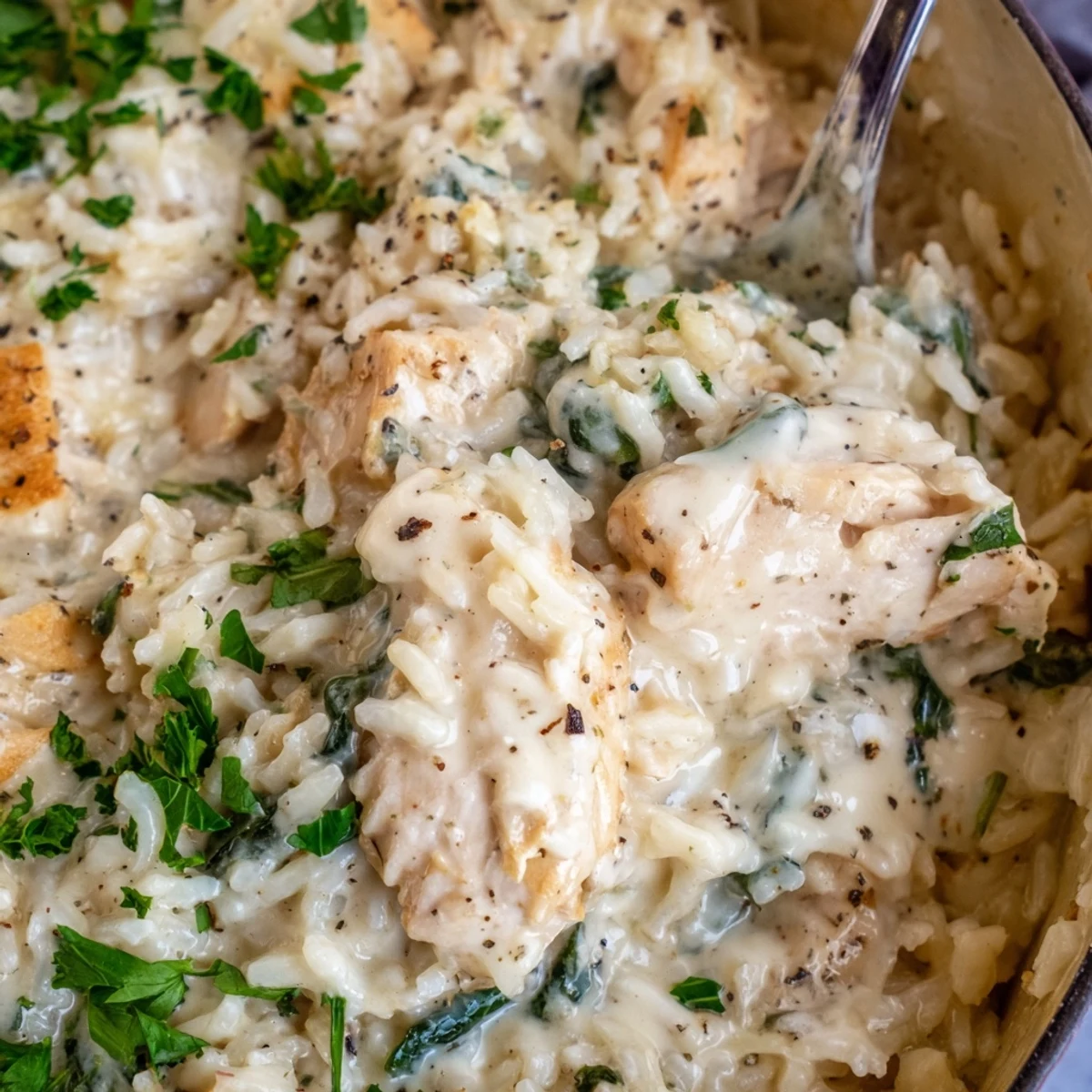 Creamy chicken and rice casserole bubbling in one pot with parmesan sauce and spinach