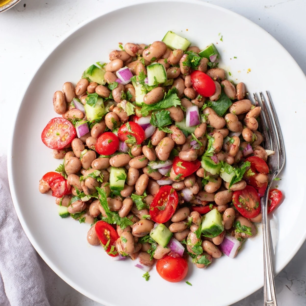 Colorful pinto bean salad tossed with crisp veggies and zesty lime dressing in a bright bowl