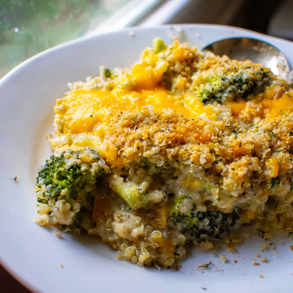 Creamy broccoli quinoa casserole scooped onto a plate for a cozy family dinner