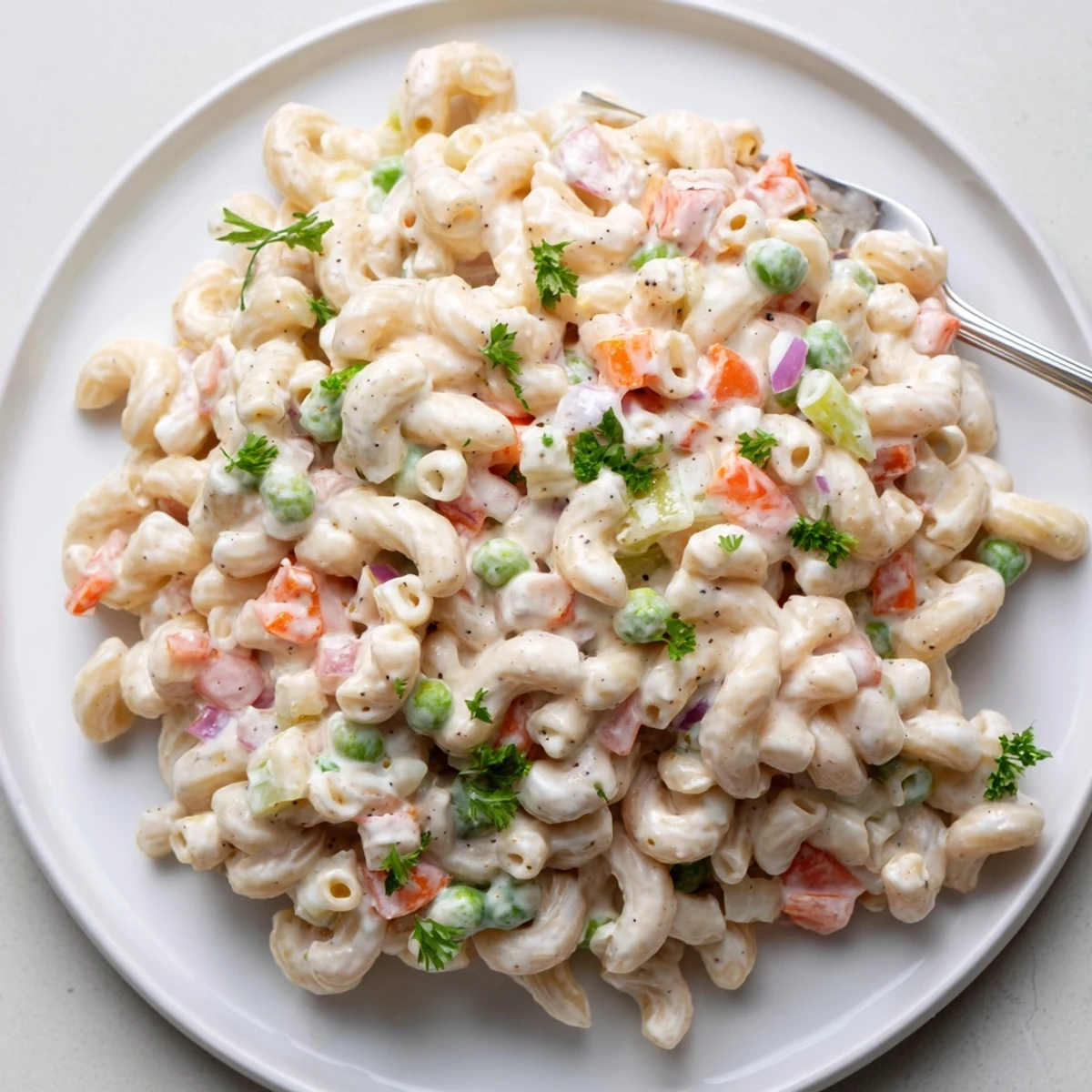 Summer picnic Macaroni Salad dotted with red pepper, peas, and chopped egg