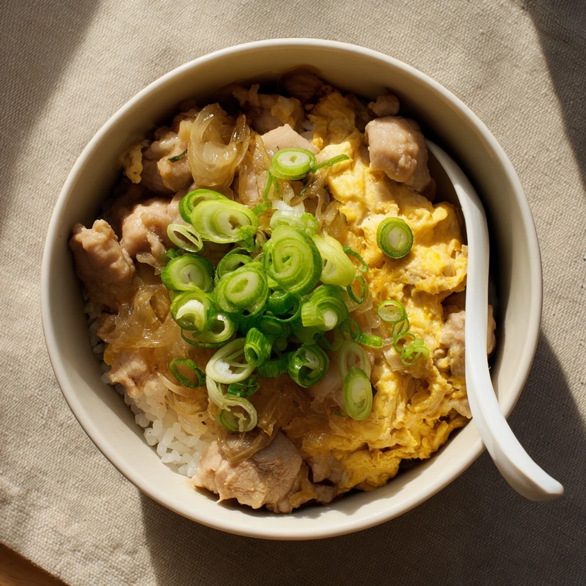 Golden one pot Oyakodon simmered in savory dashi soy sauce and garnished with fresh green onions