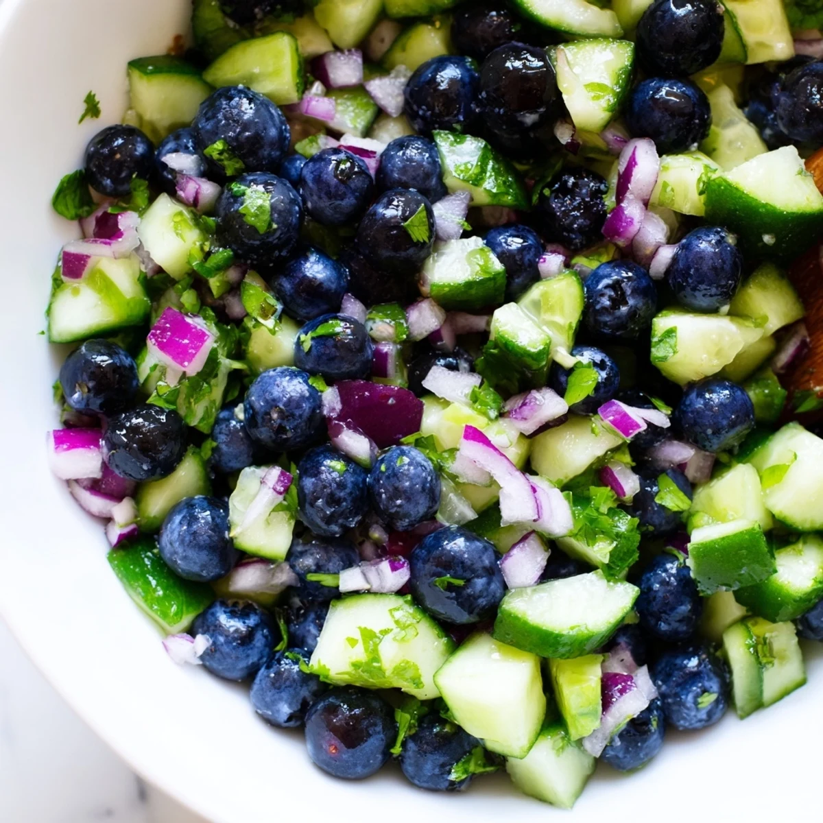A close-up of blueberry cucumber salsa served with tortilla chips at a summer cookout